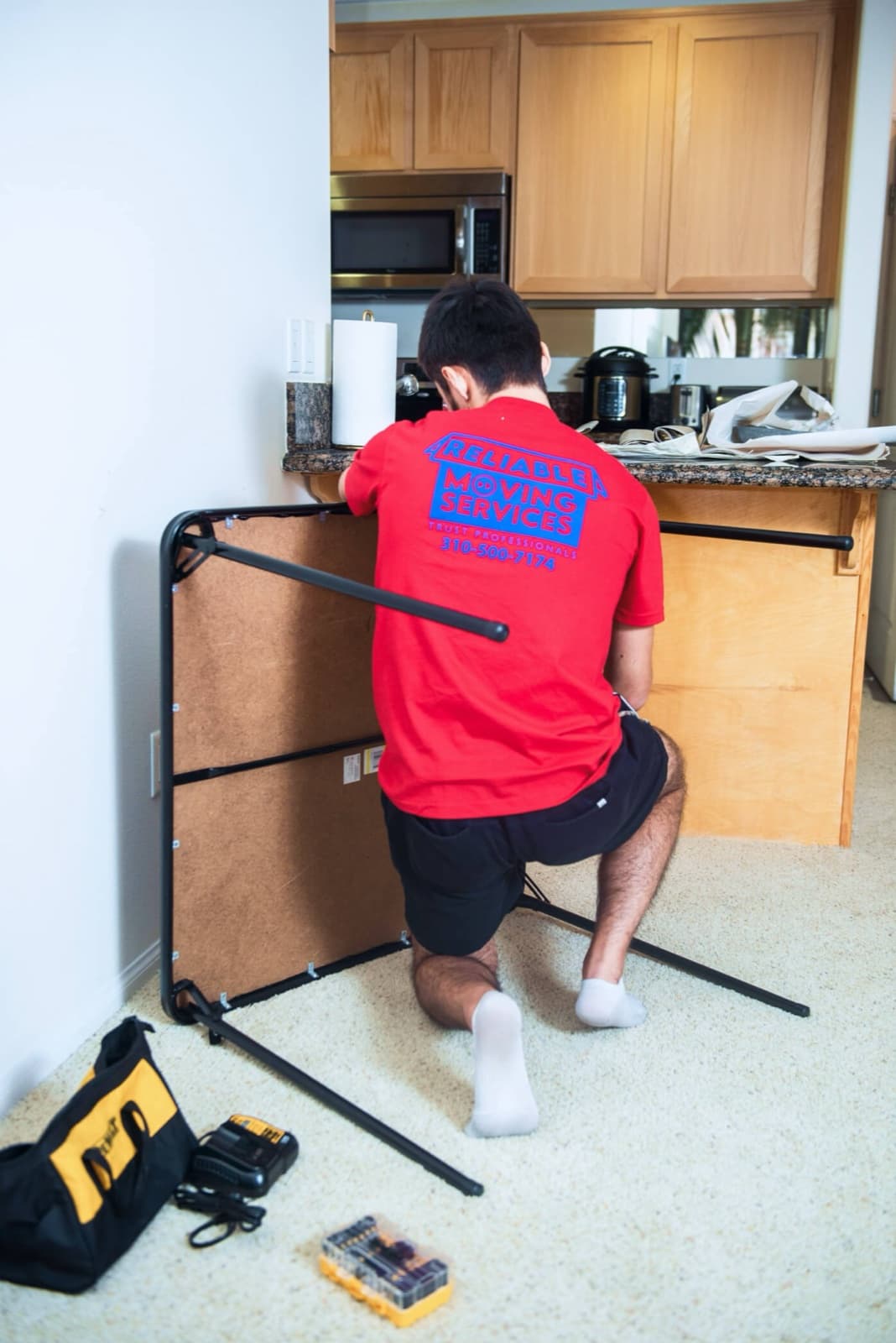 Mover disassembling a bed frame in the apartment